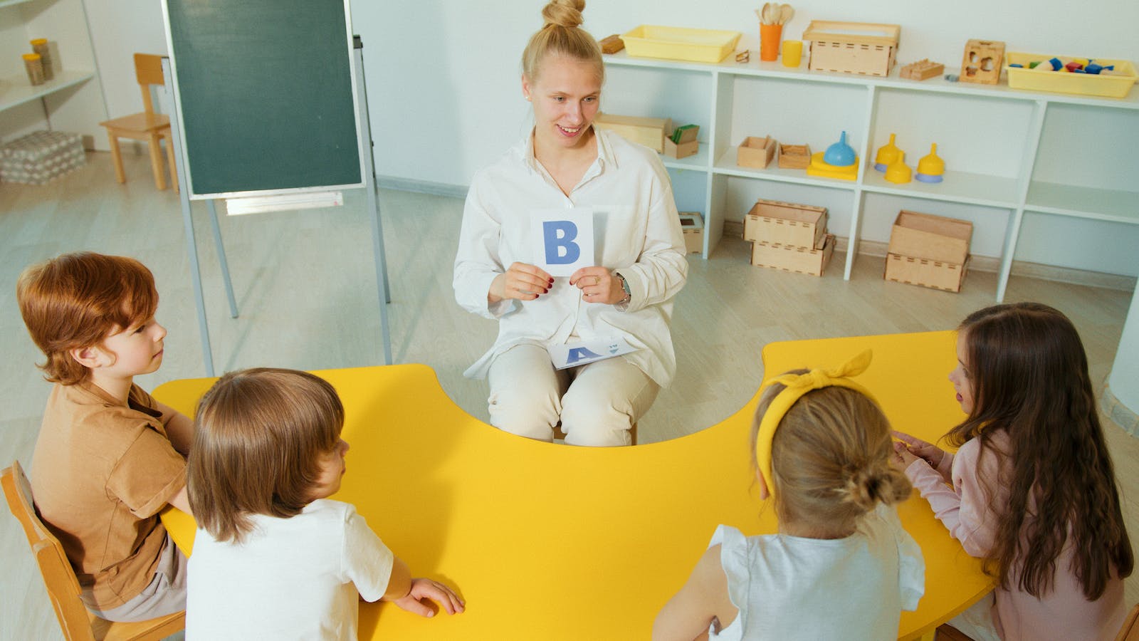A Woman in White Long Sleeves Sitting in Front of the Kids